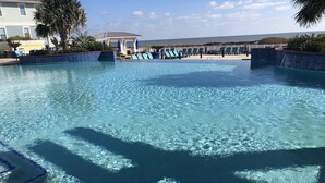 Una piscina limpida con lettini e un padiglione.