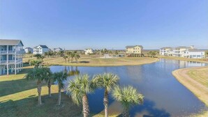 Una zona residenziale con un ampio specchio d'acqua, diverse case e palme.