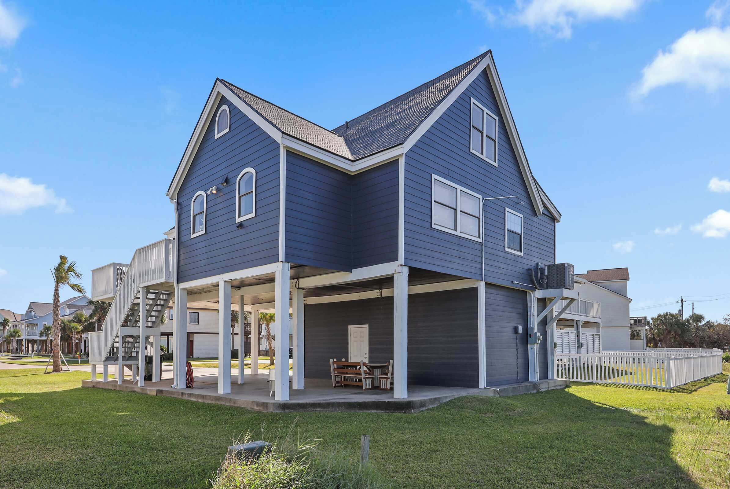 A two-story house with a covered porch and a staircase leading to an upper level.