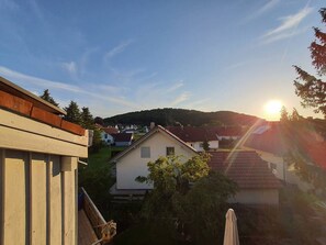 Un quartier résidentiel avec des maisons, un ciel dégagé et le soleil se couchant ou se levant.