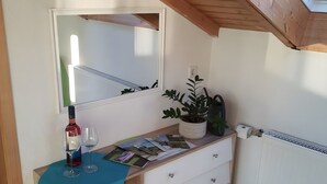 A room with a wooden desk, a mirror, a radiator, and a window with blinds. - Brendle Apartment with Balcony and Wi-Fi (Sankt Johann)