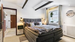 A bedroom with a large bed, bedside lamps, a window with curtains, and a view of the outdoors. - Apartment 'Küstenliebe' with Shared Terrace, Shared Garden and Wi-Fi (Lehe)
