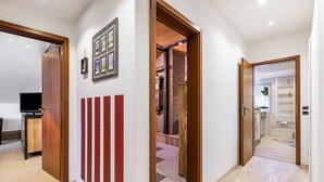 A hallway with a wooden door, a red and white striped wall, and a brick wall in the background. - Apartment 'Küstenliebe' with Shared Terrace, Shared Garden and Wi-Fi (Lehe)