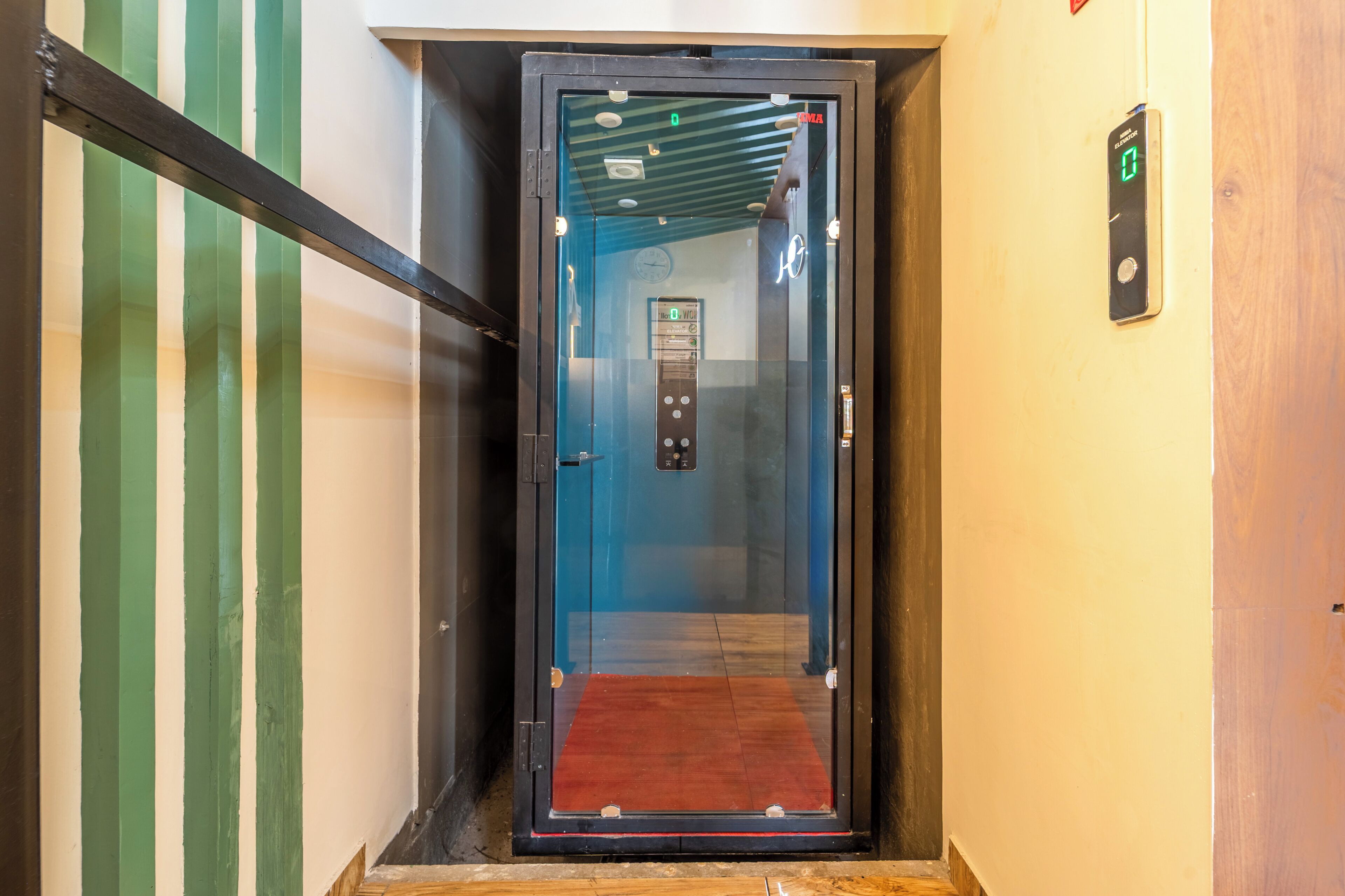 An elevator with a digital display, a red carpet, and a wall-mounted sign.