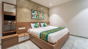 A modern bedroom with a wooden bed, a built-in wardrobe, a large mirror, and a ceiling fan. - Treebo MR Motel, 10 Mins To Airport (Iritty)