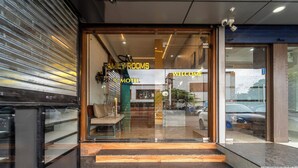 A motel entrance with a glass door, steps leading up to it, and a bench inside. - Treebo MR Motel, 10 Mins To Airport (Iritty)