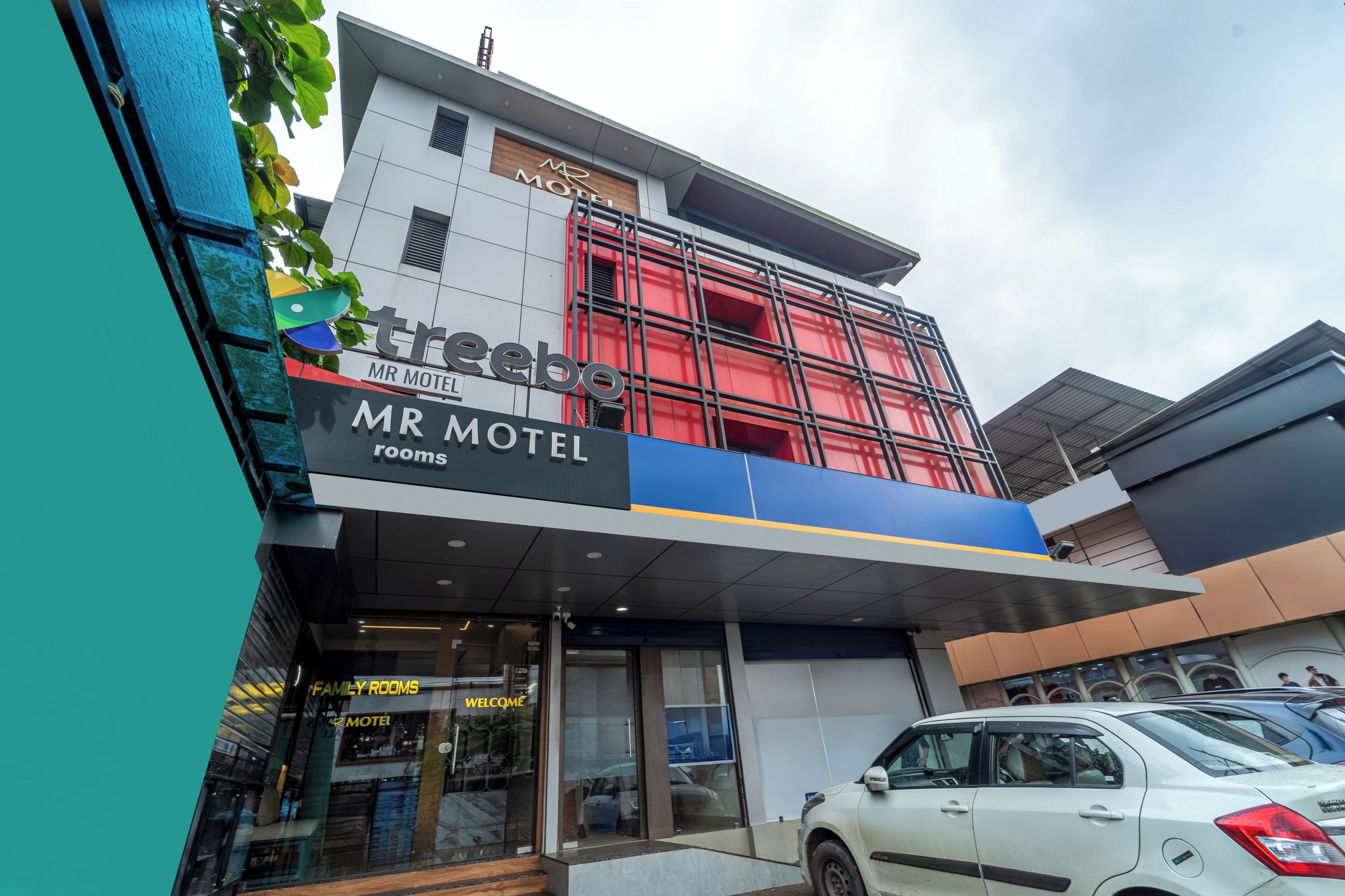 A modern motel building with a prominent sign for 'Mr Motel' and 'Family Rooms.'