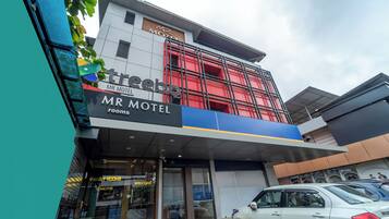 A modern motel building with a prominent sign for 'Mr Motel' and 'Family Rooms.'