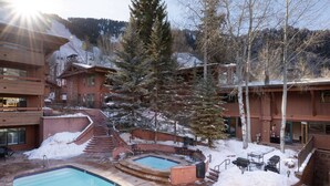 Un resort con piscina, mobiliario exterior y un paisaje nevado.