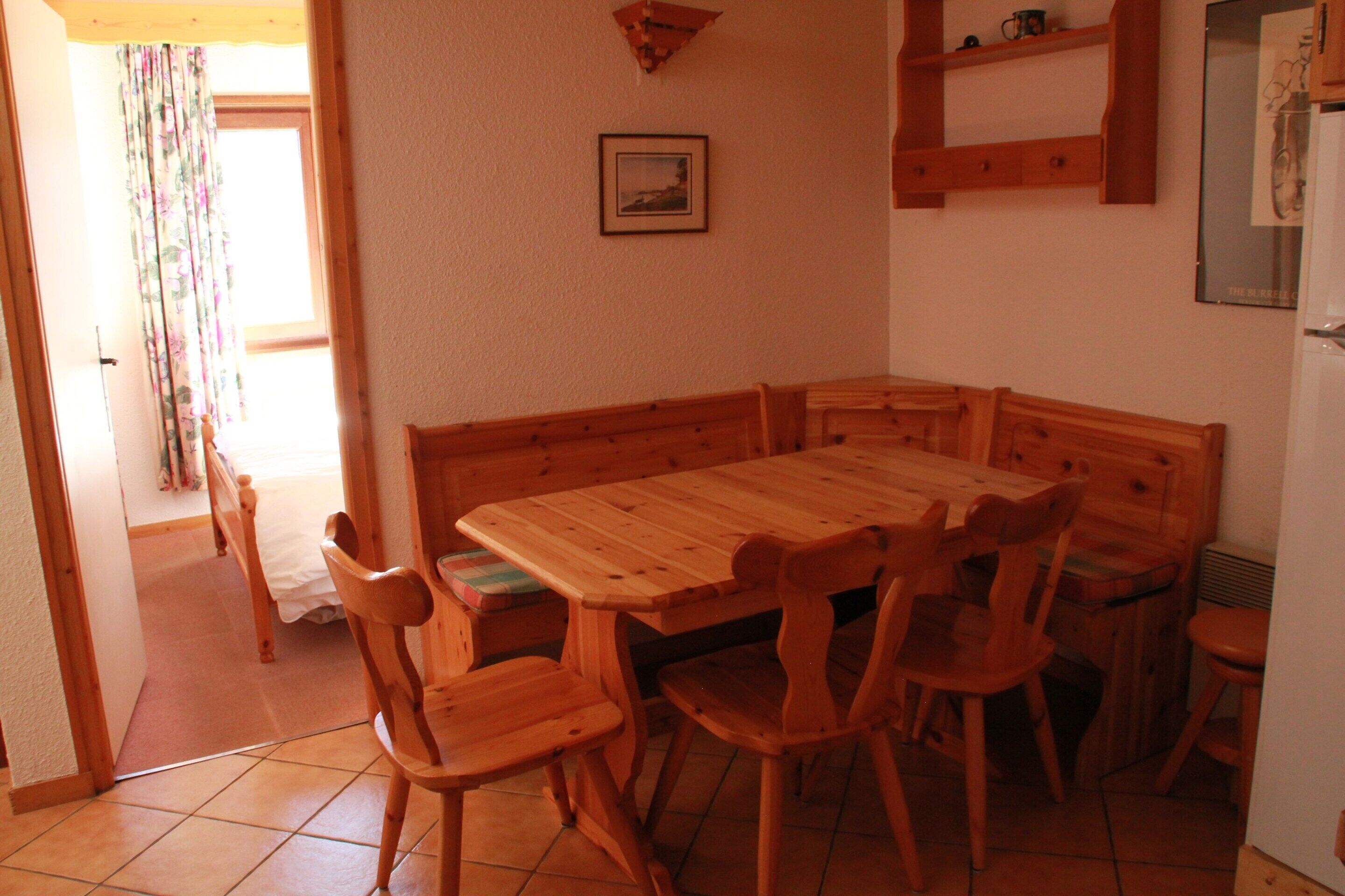 Un tavolo da pranzo in legno con sei sedie, una panca in legno e un piccolo ripiano sopra il tavolo.