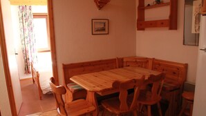 A wooden dining table with six chairs, a wooden bench, and a small shelf above the table. - Sorbiers Ss11 View & Quiet 6 Pers (Chatel)