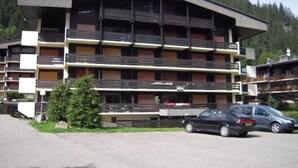 Un hôtel à plusieurs étages doté de balcons, d’un parking et situé dans un cadre montagneux.