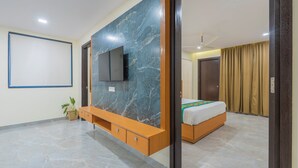 Une chambre à coucher moderne, dotée d’une grande télévision, d’un lit et d’une console.
