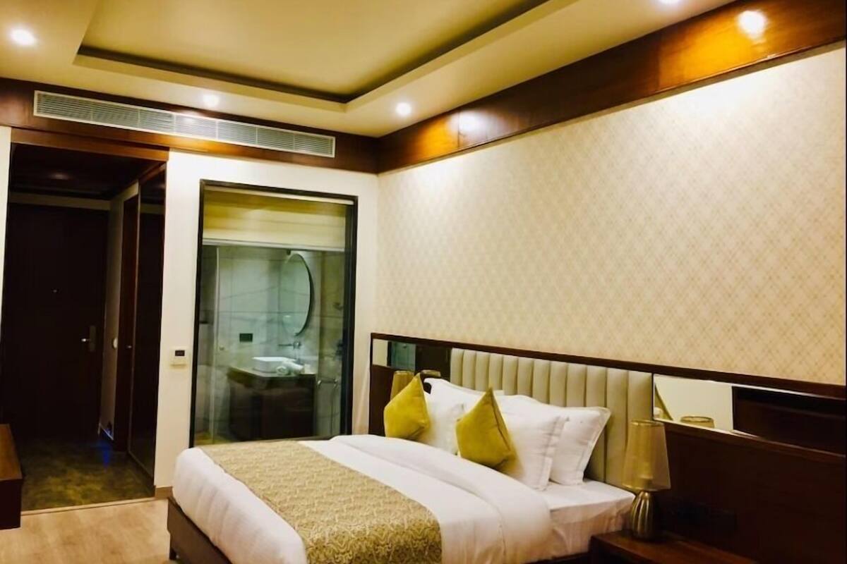 Ein Hotelzimmer mit Bett, Nachttisch und Spiegel.