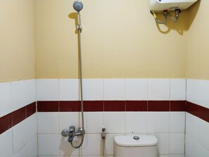 Un baño con ducha, inodoro y lavamanos empotrado.