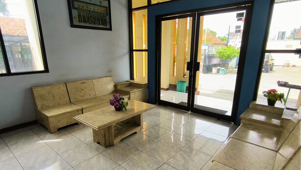 Uma área de recepção com sofá, mesa de centro e um quadro na parede.