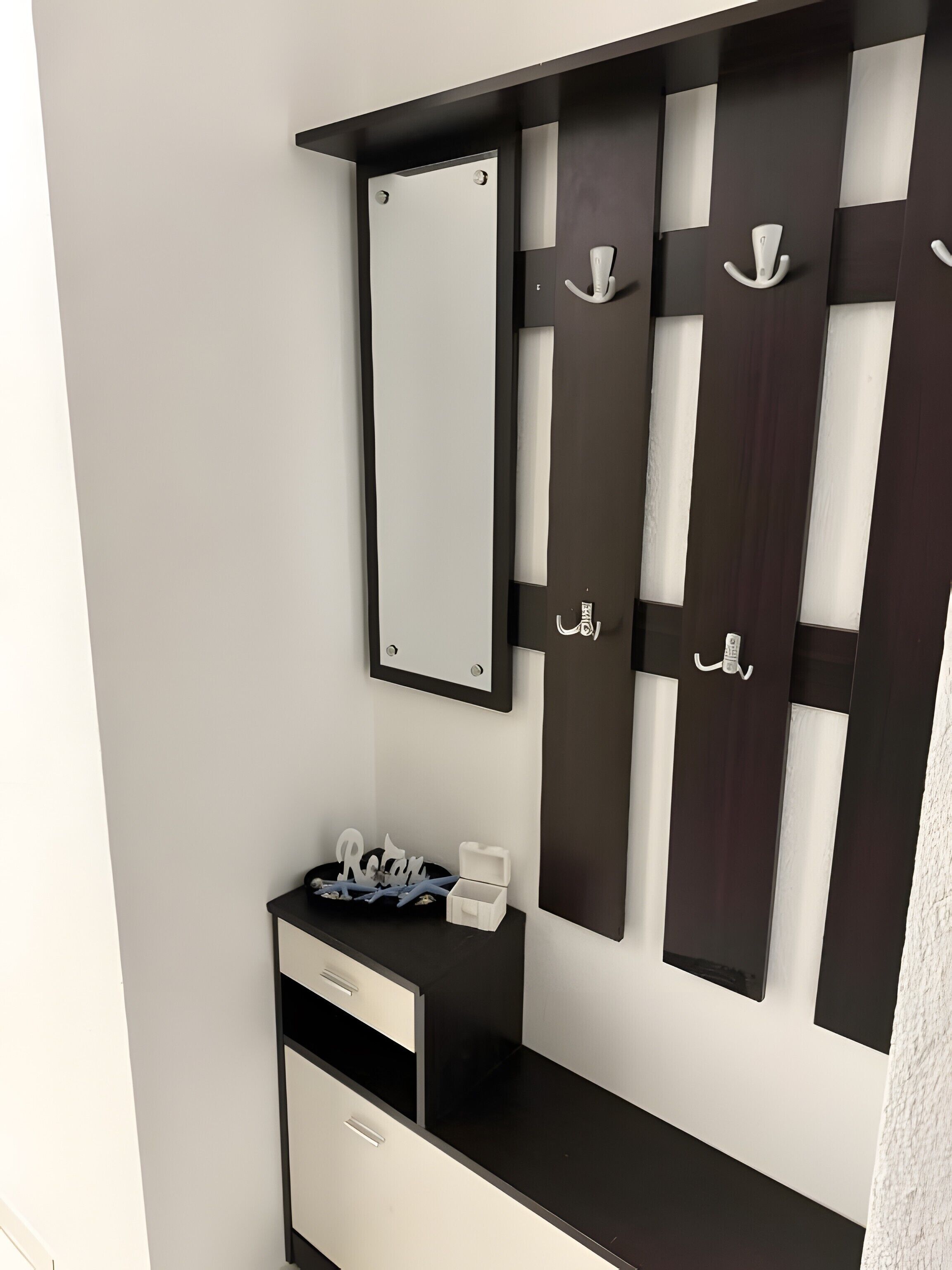 A modern room with a black and white vanity, a mirror, and a small table with a nameplate.