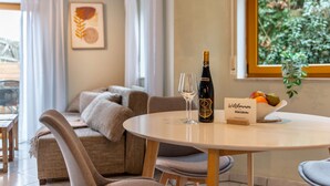 A round dining table with a bottle of wine, a glass, and a welcome sign. - Apartment 'Donauliebe' with Private Terrace, Shared Garden and Wi-Fi (Sigmaringen)