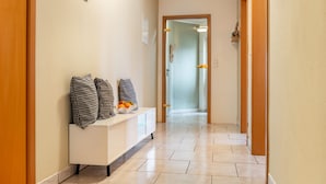 A hallway with a white console table, patterned pillows, and a bowl of oranges. - Apartment 'Donauliebe' with Private Terrace, Shared Garden and Wi-Fi (Sigmaringen)