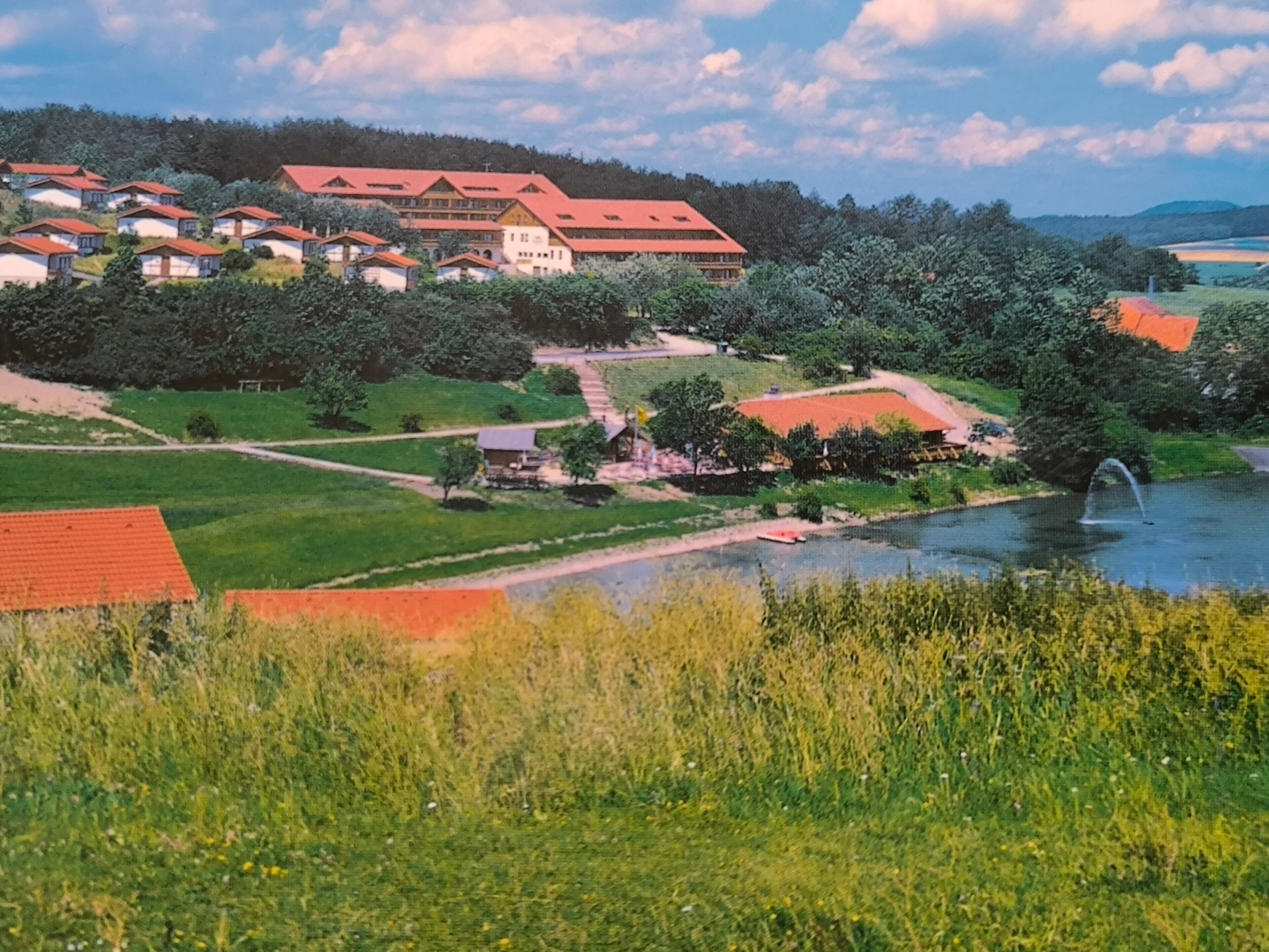 A residential area with houses, a river, and a fountain.