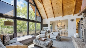 Un salon spacieux avec un haut plafond, de grandes fenêtres et un coin salon confortable.