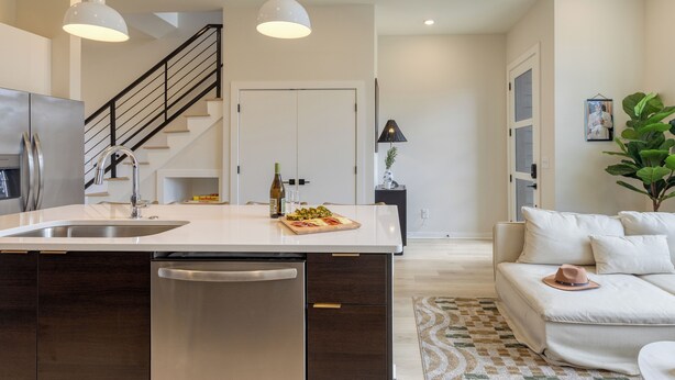 A modern kitchen with a central island, stainless steel appliances, and pendant lighting. - Newly Built 4BDR Townhome w/ Balcony, Minutes to Broadway | Lischey by AvantStay (Nashville)