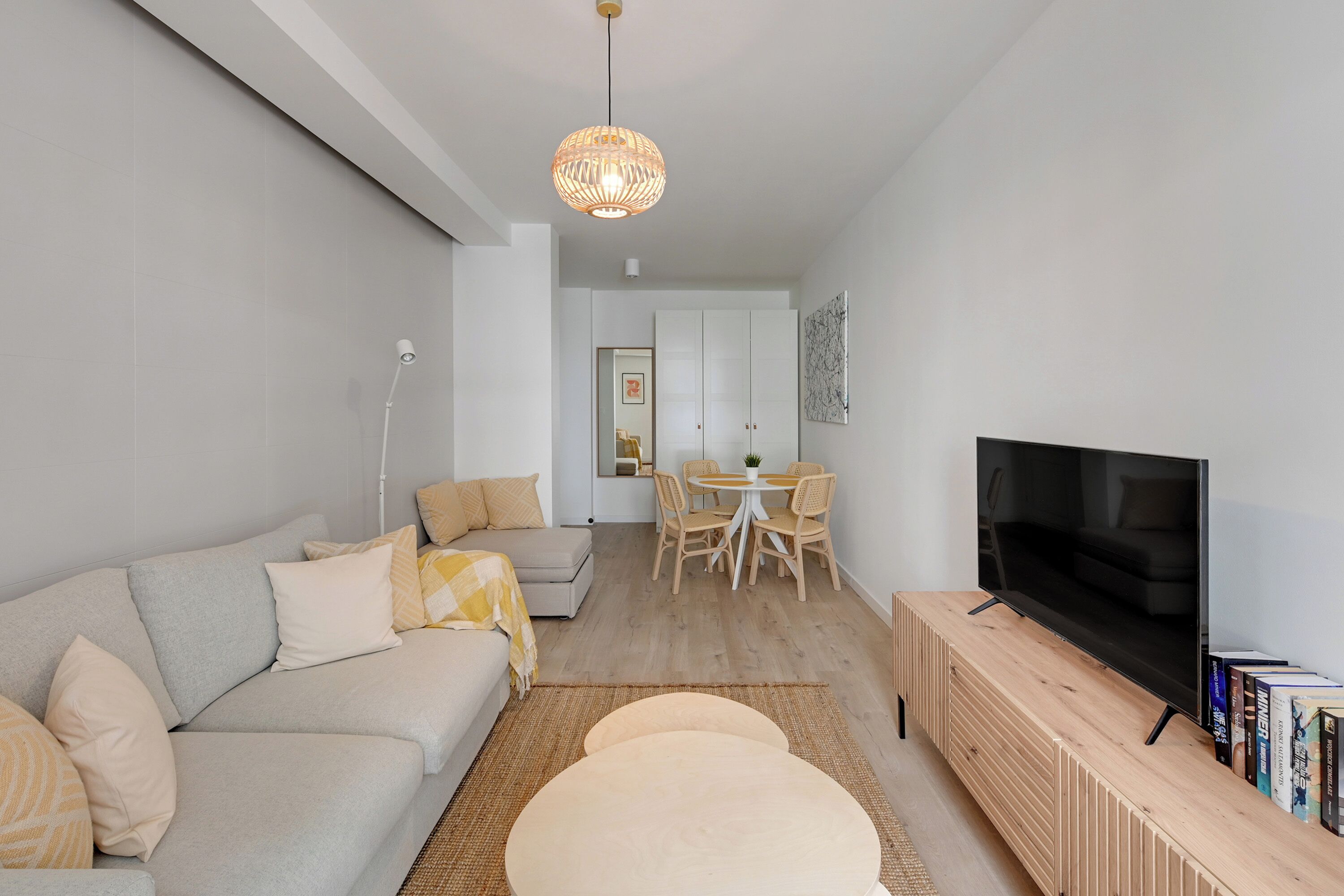 Un salon moderne avec un canapé, un téléviseur et un meuble de rangement en bois.