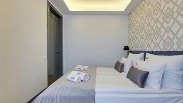 Een hotelkamer met een bed, twee kussens, een nachtkastje en een lamp.