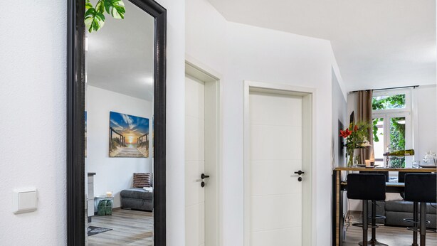 A modern interior with a dining area, a sofa, and a painting on the wall. - Apartment 'Marktplatz Ferienwohnung' with Wi-Fi (Alsfeld)