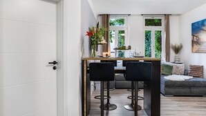 A modern kitchen with a dining area, a sofa, and a painting on the wall. - Apartment 'Marktplatz Ferienwohnung' with Wi-Fi (Alsfeld)
