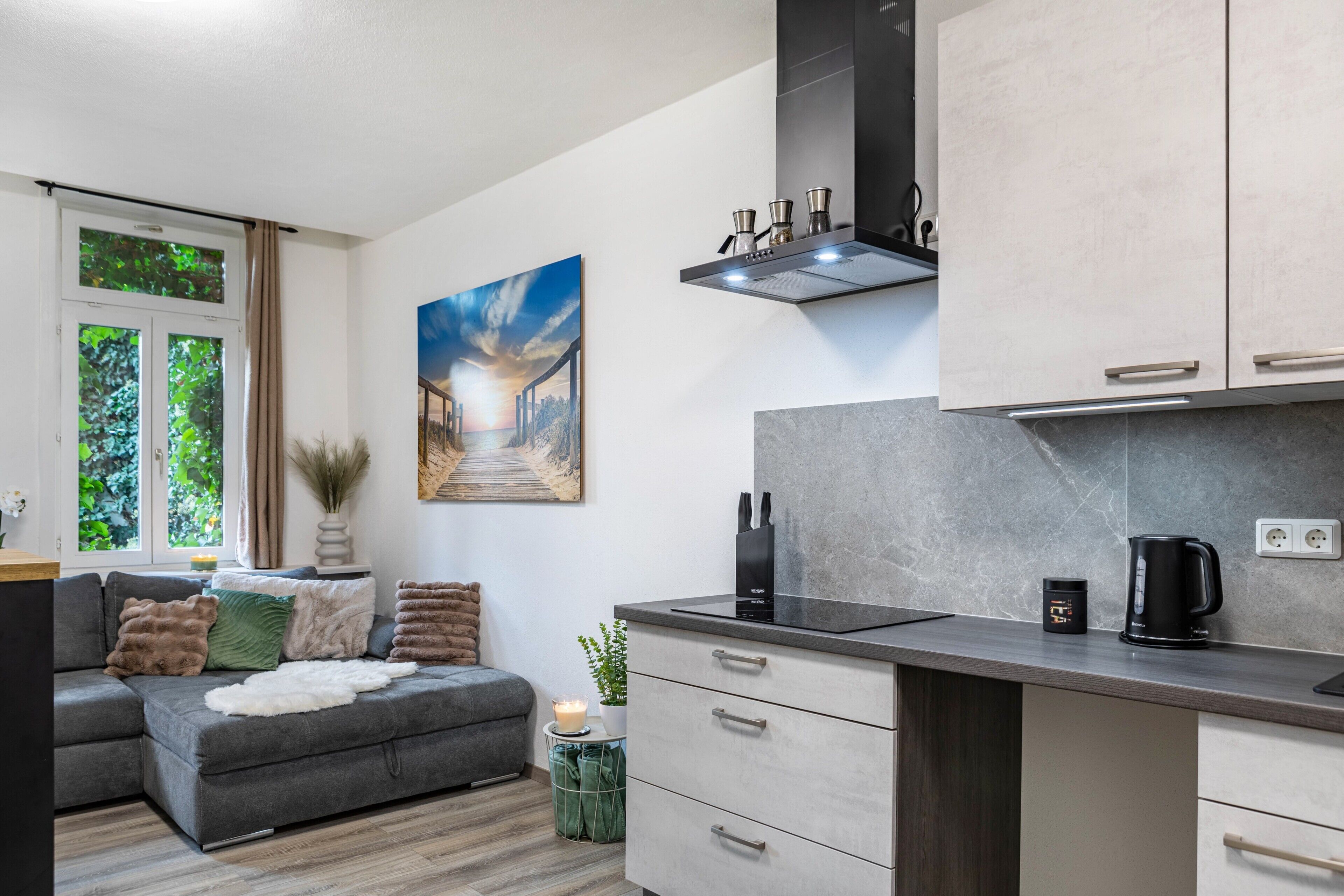 A modern kitchen with a built-in oven, a coffee machine, and a small countertop.