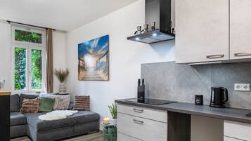 A modern kitchen with a built-in oven, a coffee machine, and a small countertop.