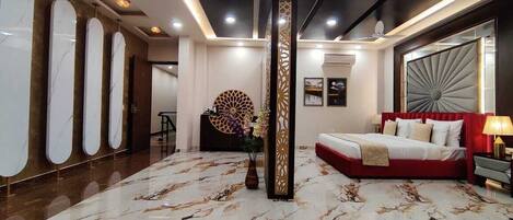 A modern hotel lobby with a marble floor, a red sofa, and a large decorative column.