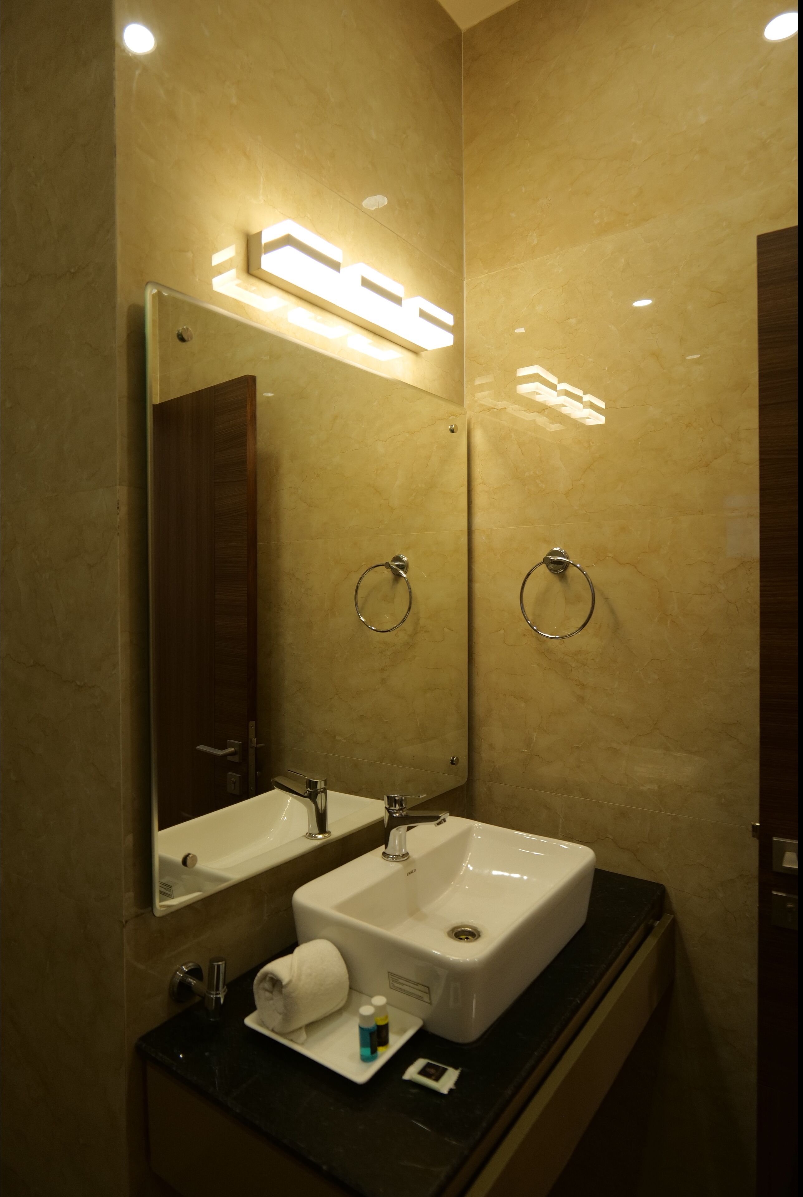 Une salle de bain avec deux lavabos, un miroir et un porte-serviettes.