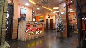 Una zona de recepción con un mostrador de madera, un árbol de Navidad y un cartel que dice "OSSA FACTORY".