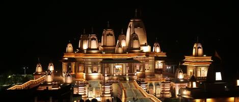 A large, illuminated temple complex at night with multiple spires and a central main building.