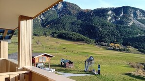 A balcony with a view of a mountainous landscape, a small wooden cabin, and a water pump. - Terrasses D 501 - Parc Nat. Vanoise Appart. 5 Pers (Val-Cenis)
