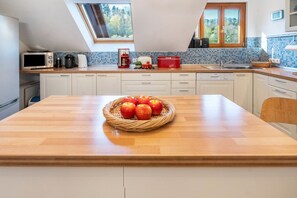 Una cocina con encimera de madera, microondas, cafetera y fregadero.