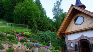 A rustic building with a stone facade, a wooden roof, and a circular window. - Holiday Home with Mountain View, Large Terrace and Wi-Fi (Baden-Baden)