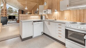 Une cuisine moderne avec des meubles blancs, un four encastré et un four à micro-ondes.