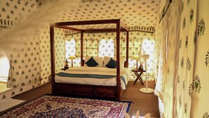 A four-poster bed with a canopy, a patterned wall, and a large rug. - Bookmark Shivir (Phulpur)