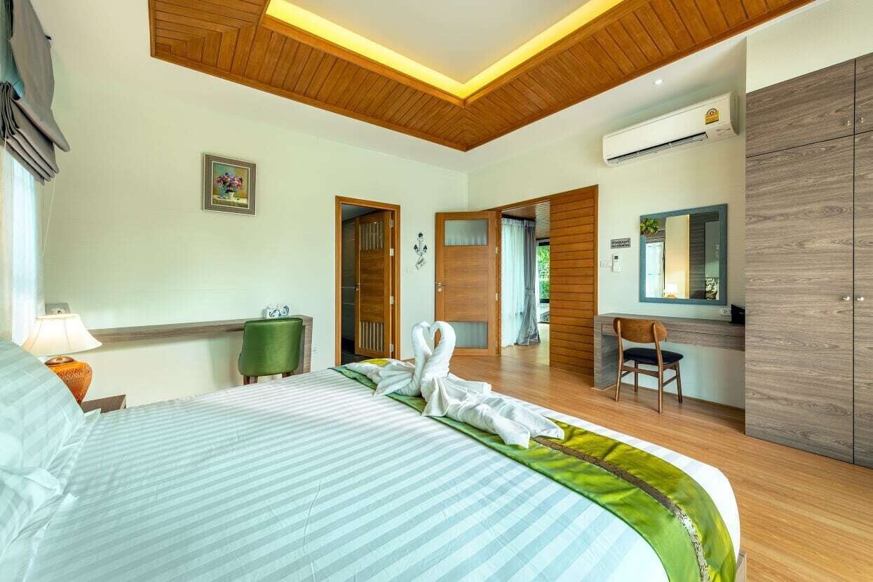 A hotel room with a bed, a desk, a chair, a wardrobe, and a bathroom door.