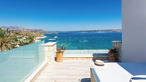 A balcony with a view of the sea, potted plants, and a hat on the railing. - Miraida Exclusive Residence (Apokoronos)