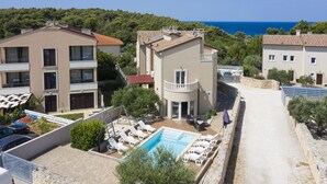 A residential area with a swimming pool, multiple buildings, and a view of the sea. - Villa Chiara with a private pool and sauna (Premantura)
