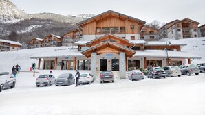 En byggnad som tillhör ett skidområde, med flera balkonger och en entré av sten.