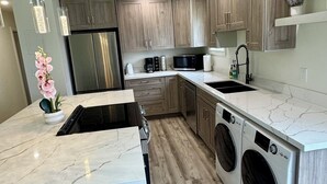 Una cocina moderna con armarios de madera, electrodomésticos de acero inoxidable y encimera de mármol.