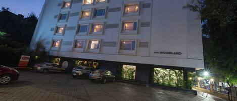 A multi-story hotel with a modern design, featuring a prominent 'Hotel Woodland' sign.