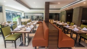 A long dining table with multiple chairs, a central bench, and a modern interior design. - The Fern Residency Pune, Woodland, Series by Marriott (Pune)