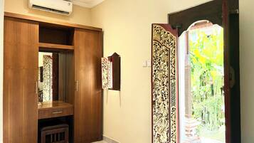 A room with a wooden wardrobe, a small bench, and a decorative panel on the wall.
