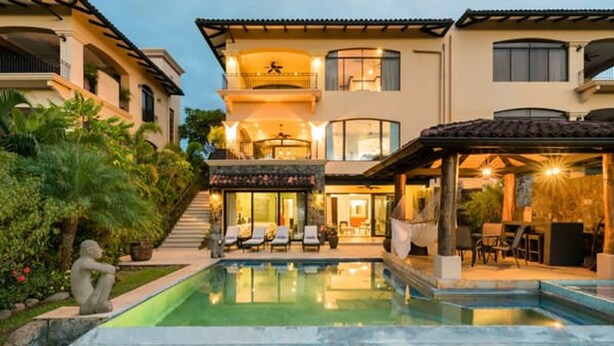 A two-story house with a swimming pool, outdoor seating, and a covered patio. - Villa Essencia in Brasilito (Cabo Velas)
